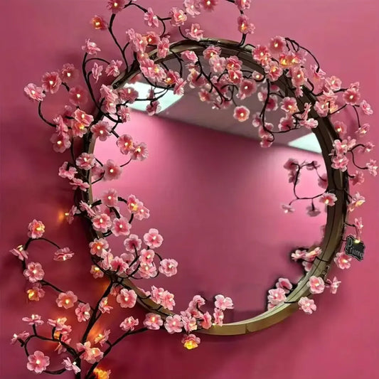 cherry blossom branch shaped led lights on mirror hanging on a pink wall
