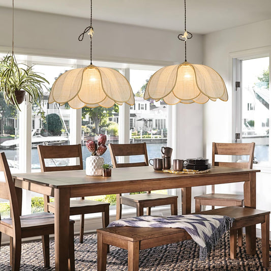 Dining room with wooden table, chairs, and pendant lights in a bright room.