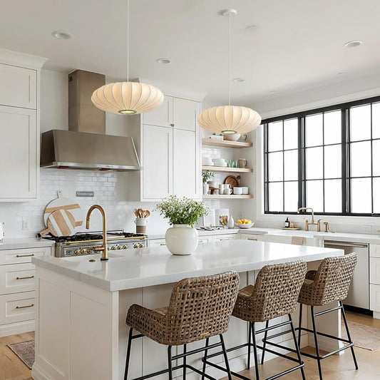 A bright modern kitchen with white cabinetry, a white island countertop, pendant lights, woven bar stools, and a large black-framed window. A 'fivemengo' watermark appears in the top-left corner.