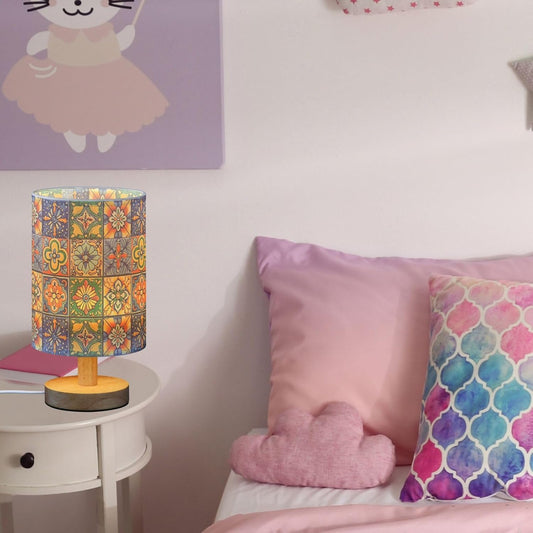 Colorful lamp on a nightstand next to a bed with patterned pillows