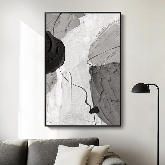 Abstract art print in a black frame on a wall above a sofa.
