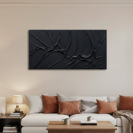 Modern living room with a black abstract wall art piece on a white wall.