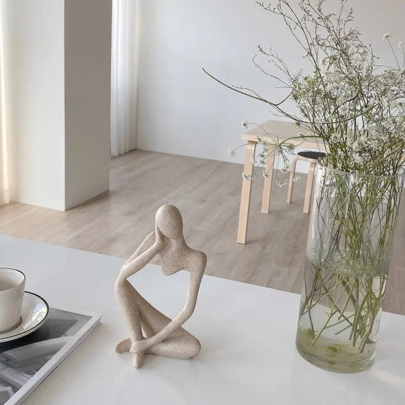 "The Thinker Statue Tabletop Art": An image of a woman statue thoughtfully sitting on a table.