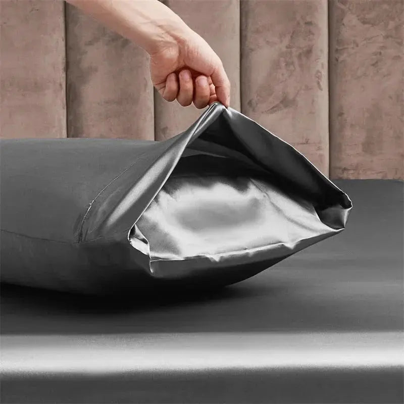 Experience the lavishness of the Opulent Satin Bed Sheet Set through its gray satin sheet, beautifully displayed on this bed.