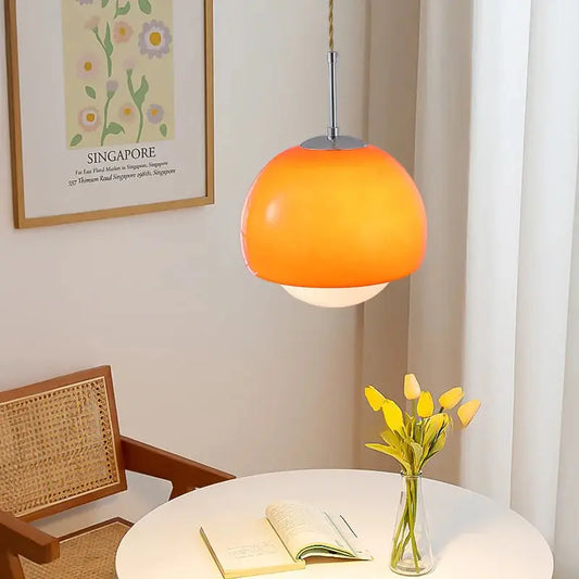 Decorative table arrangement featuring a vase of flowers and a Crystal Glow Pendant Lamp.