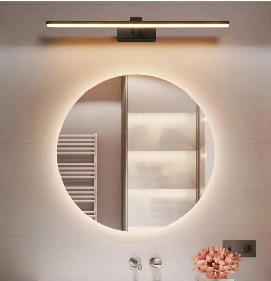 Vintage brass vanity wall sconce with frosted glass shade centered above bathroom mirror