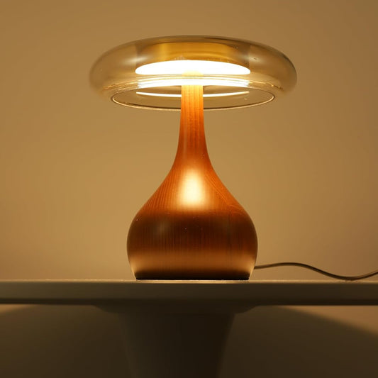 Wooden table lamp with a warm glow on a white surface against a beige wall.