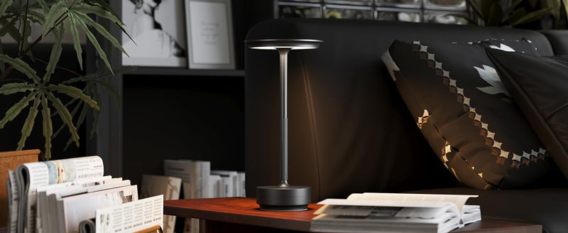 Black cordless carlo table lamp placed on a bedside of a bed