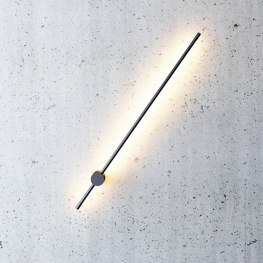 long rod wall sconce on a concrete wall with a warm light