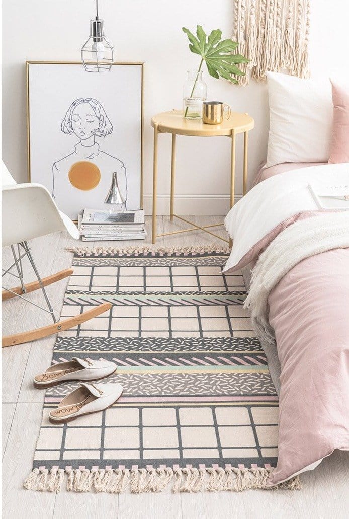 tassel rug under the bed with a chair and bed side table