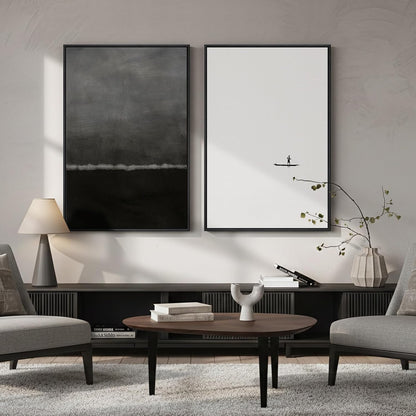 Modern living room with two framed artworks on the wall, a coffee table, and gray chairs.