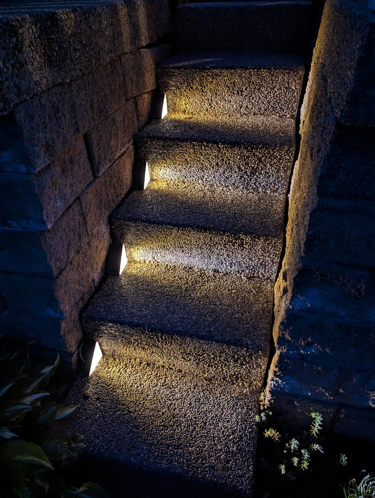 Dark stone staircase with embedded lights in a natural setting