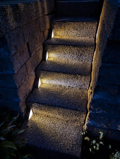 Dark stone staircase with embedded lights in a natural setting