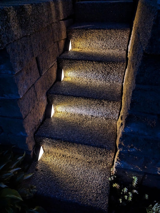 Dark stone staircase with embedded lights in a natural setting