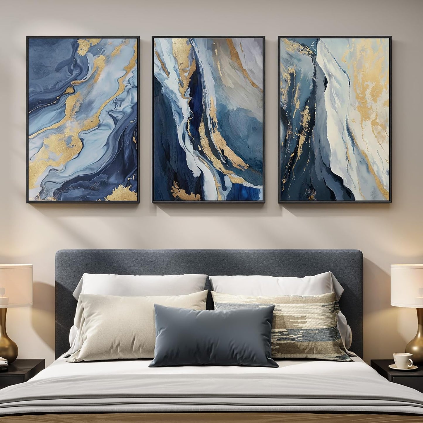 Three abstract paintings above a bed with decorative pillows.
