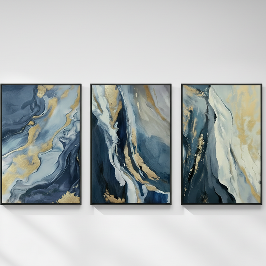 Three framed abstract wall art panels with swirling blue, white, and gold marbled patterns, displayed side by side on a beige wall with soft shadow streaks.