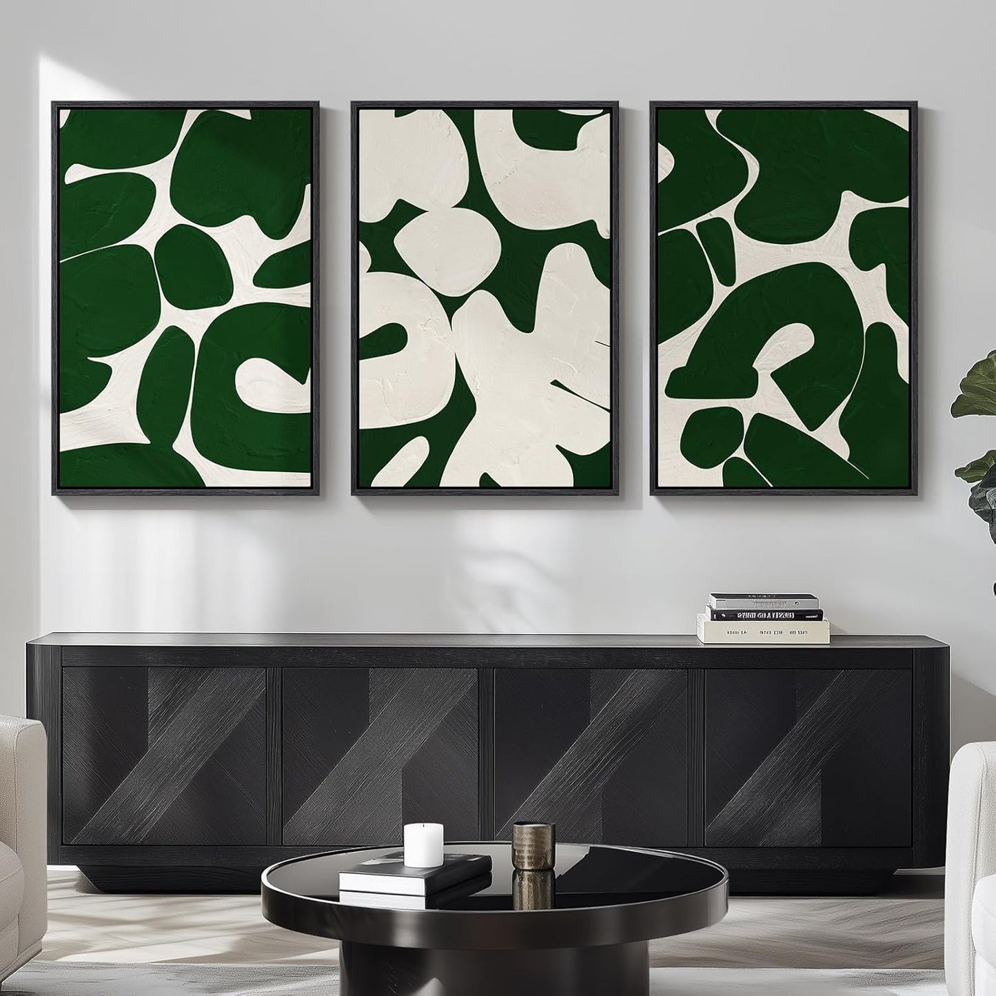 Three abstract art pieces in green and white on a wall above a black cabinet.