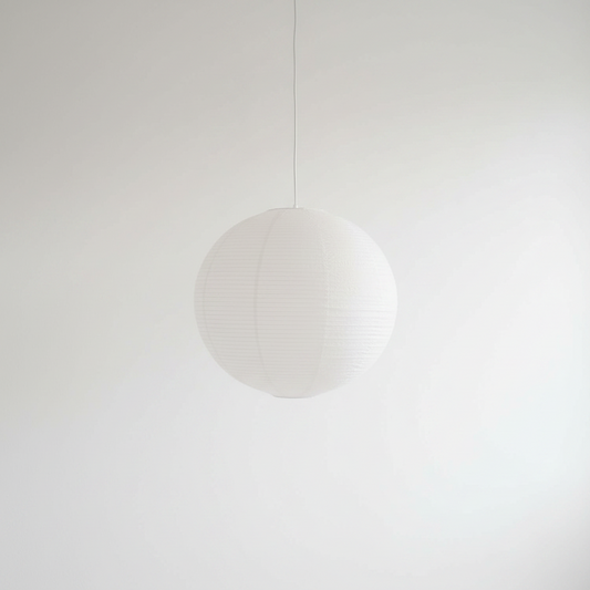 A white spherical paper lantern-style pendant light hanging from a thin cord against a plain white wall.