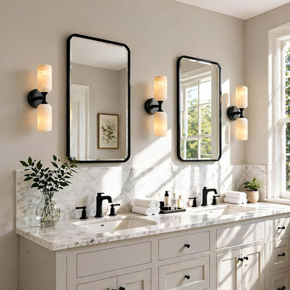 Bathroom vanity with marble countertop, mirrors, and lighting fixtures.
