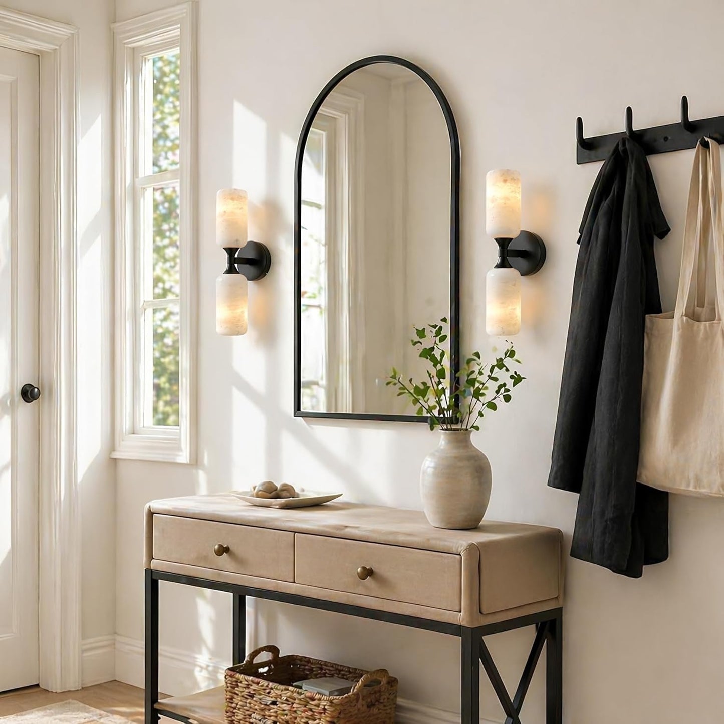 Entryway with a mirror, console table, and wall sconces.