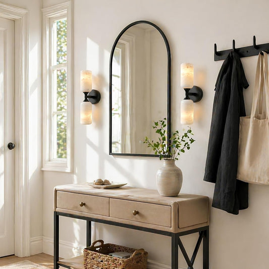 Entryway with a mirror, console table, and wall sconces.