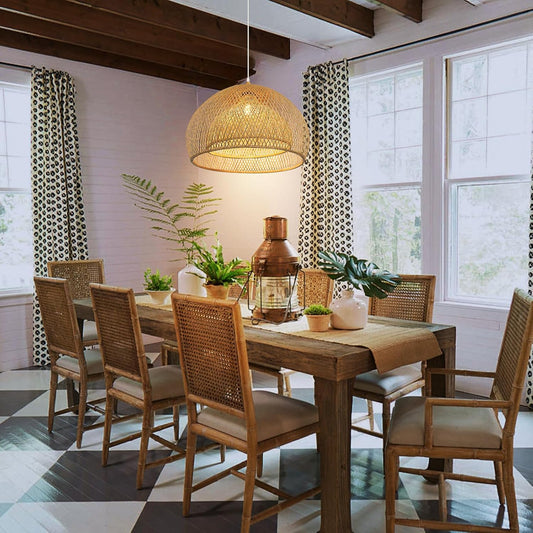 Dining room with wooden table and chairs, pendant light, and plants.