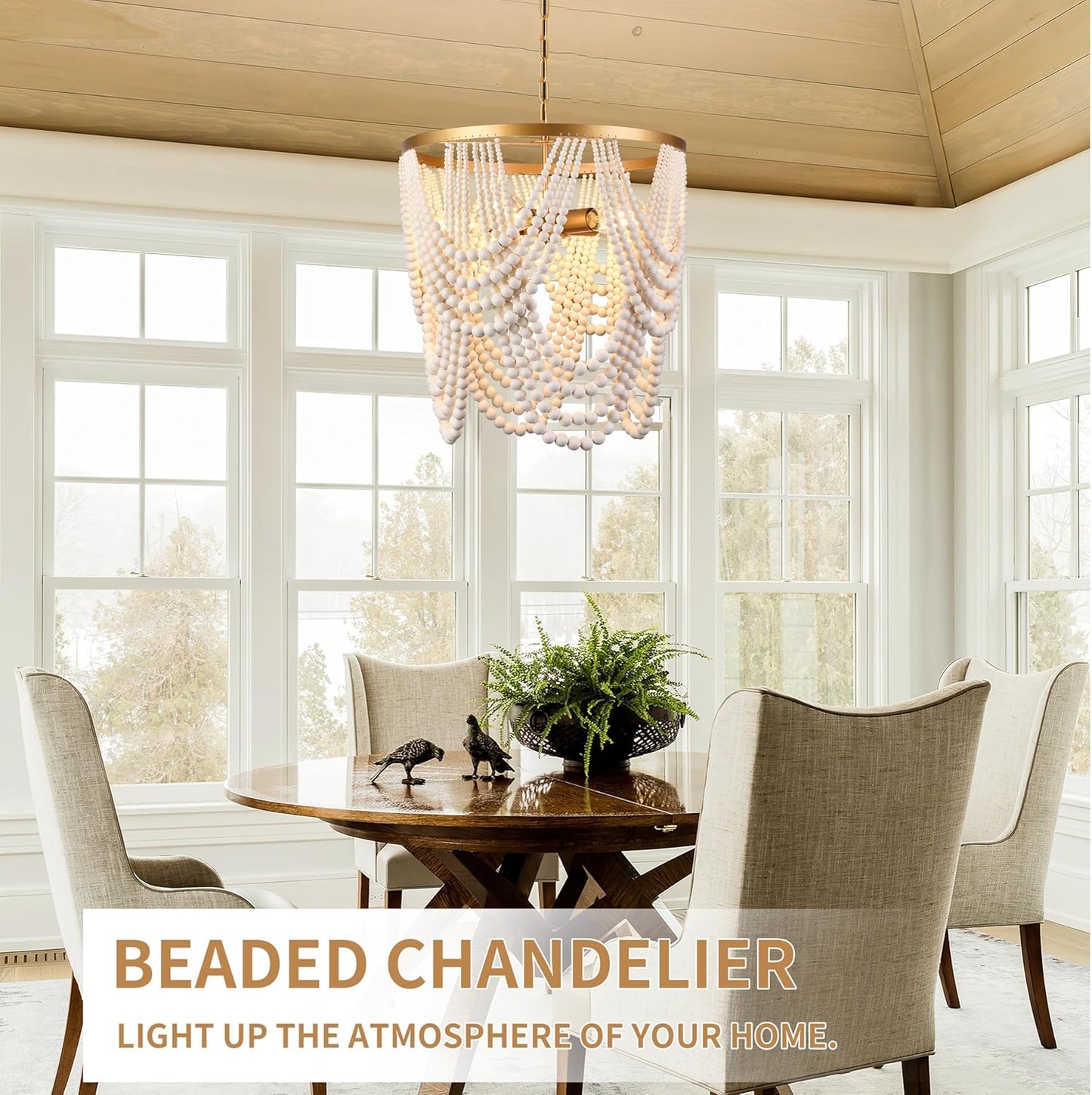 Beaded chandelier hanging above a dining table in a bright room with large windows.