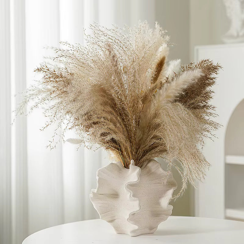 Beige donut‑shaped ceramic vase with coral‑reef scalloped silhouette, isolated
