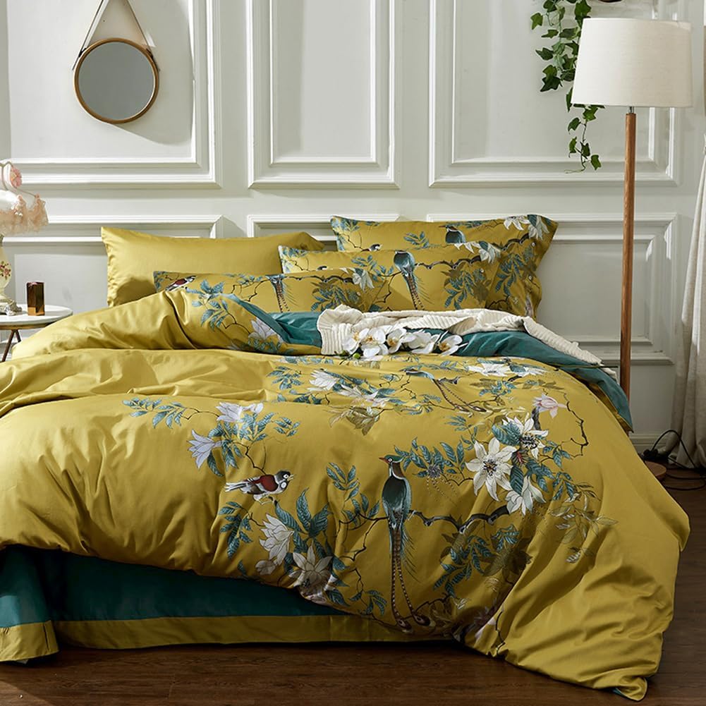 Yellow floral and bird patterned bedding set on a bed in a bedroom.