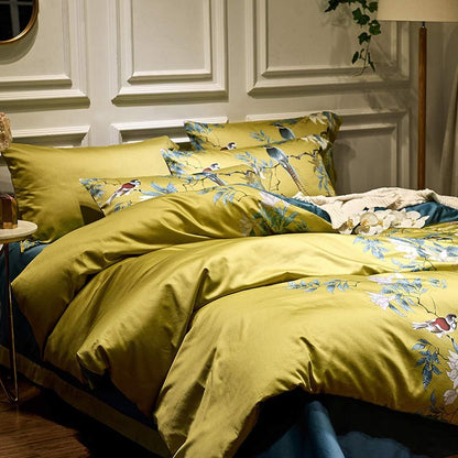 Yellow floral bedding set on a bed with decorative pillows in a bedroom setting.