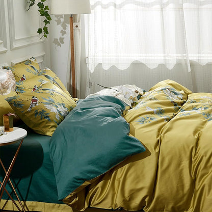 Bed with yellow floral bedding and green pillows in a bedroom setting.