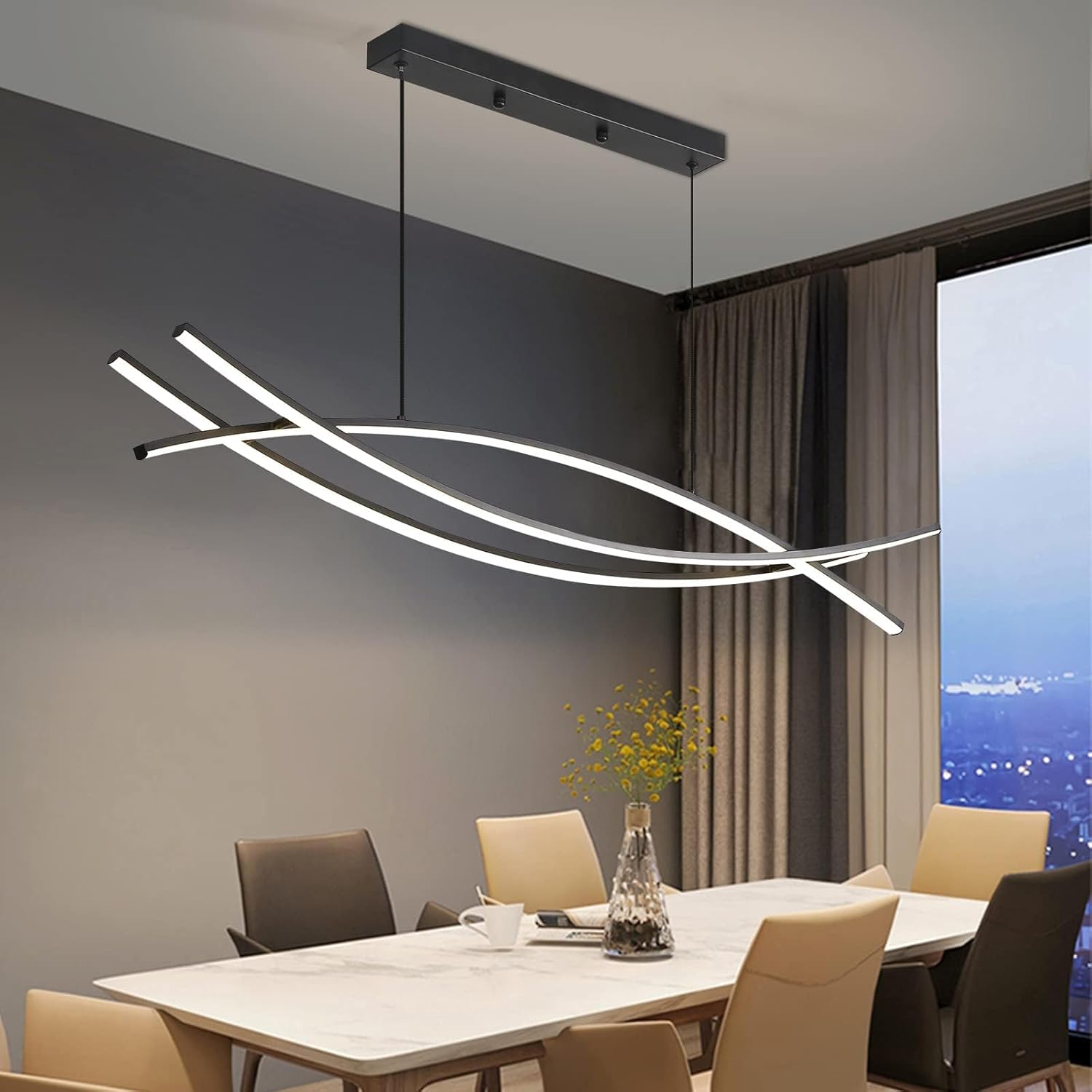 Modern LED chandelier hanging above a dining table in a room with a cityscape view.