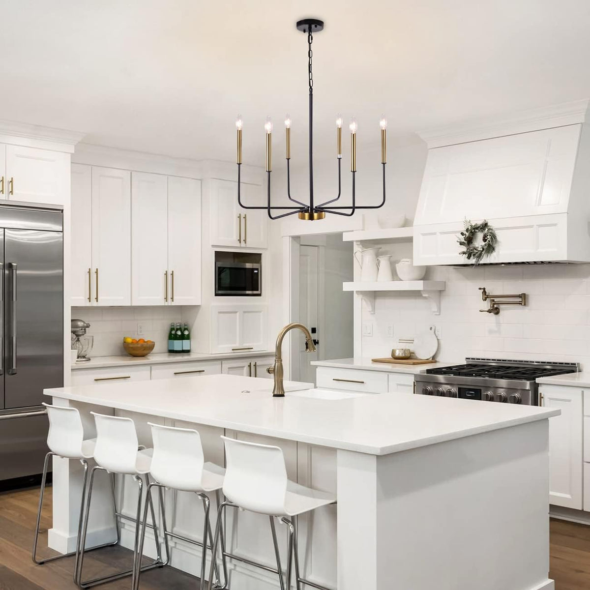 Modern kitchen with white island, bar stools, and stainless steel appliances.