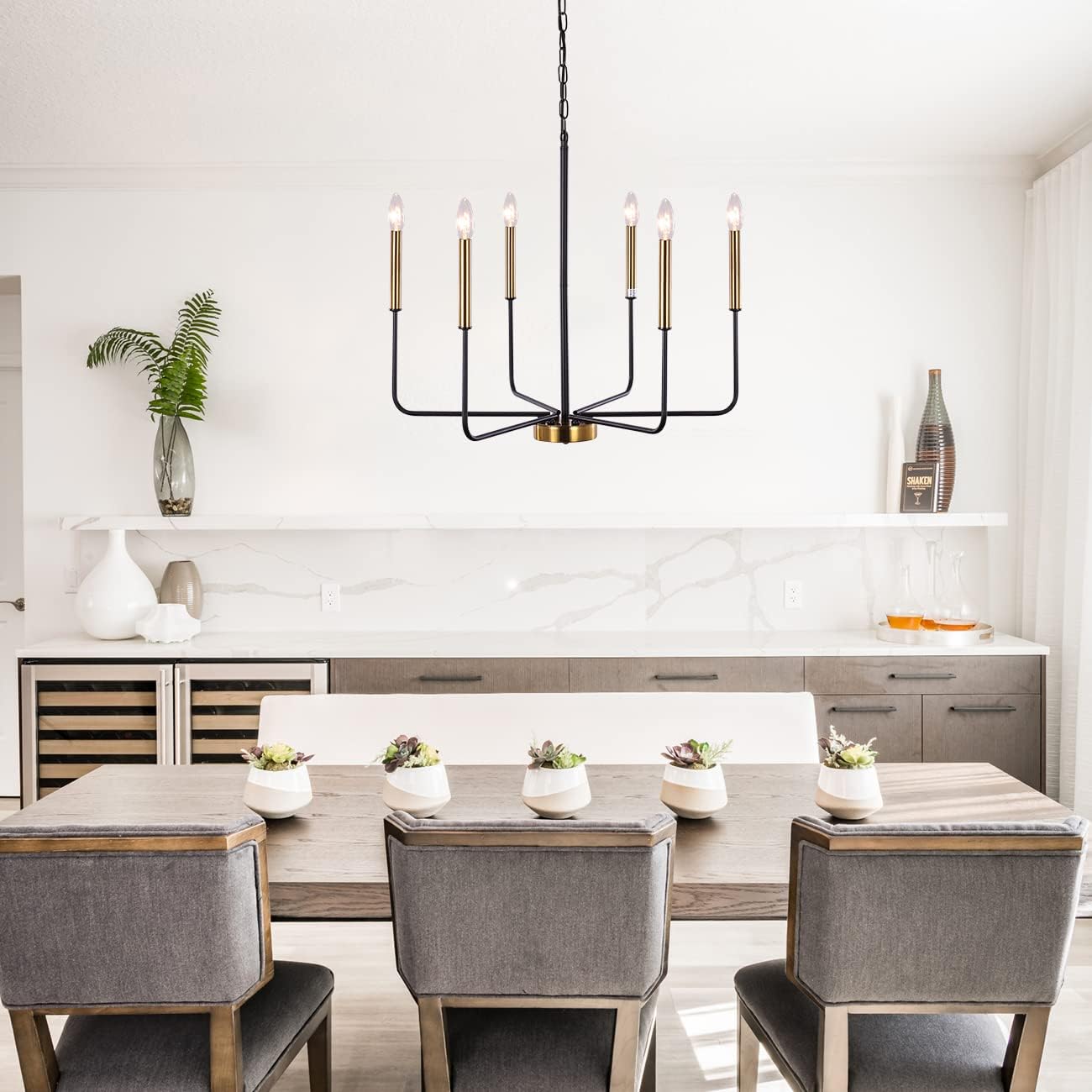 Modern dining room with a chandelier, table, and chairs.