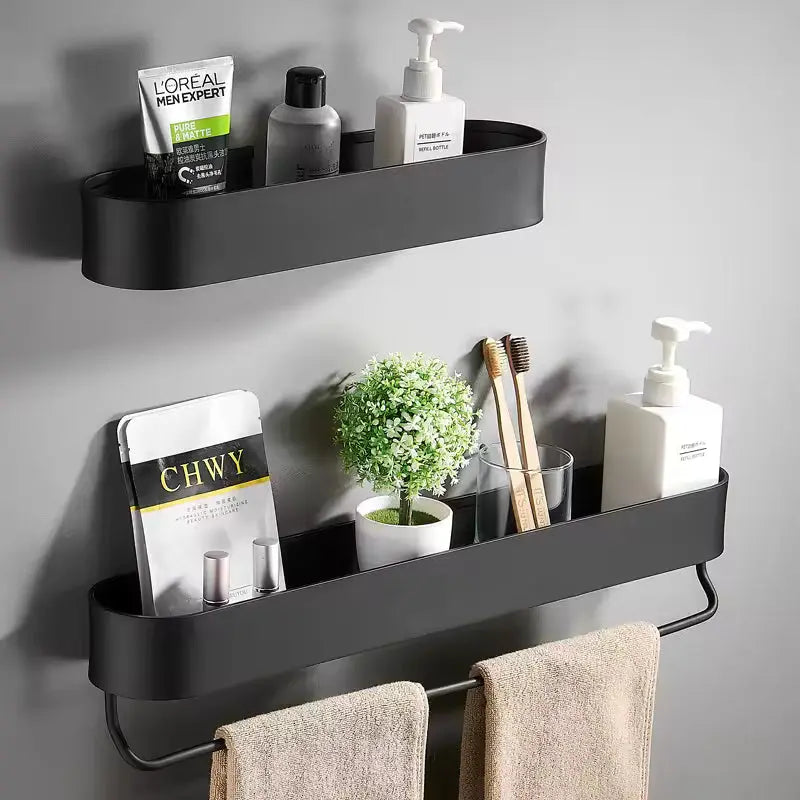 Black wall-mounted shelf with toiletries and a plant on a gray wall