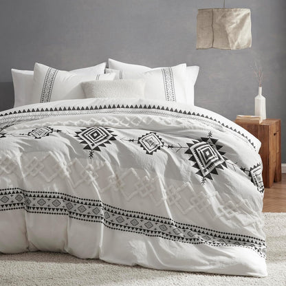 White bedding set with black geometric patterns in a bedroom setting.