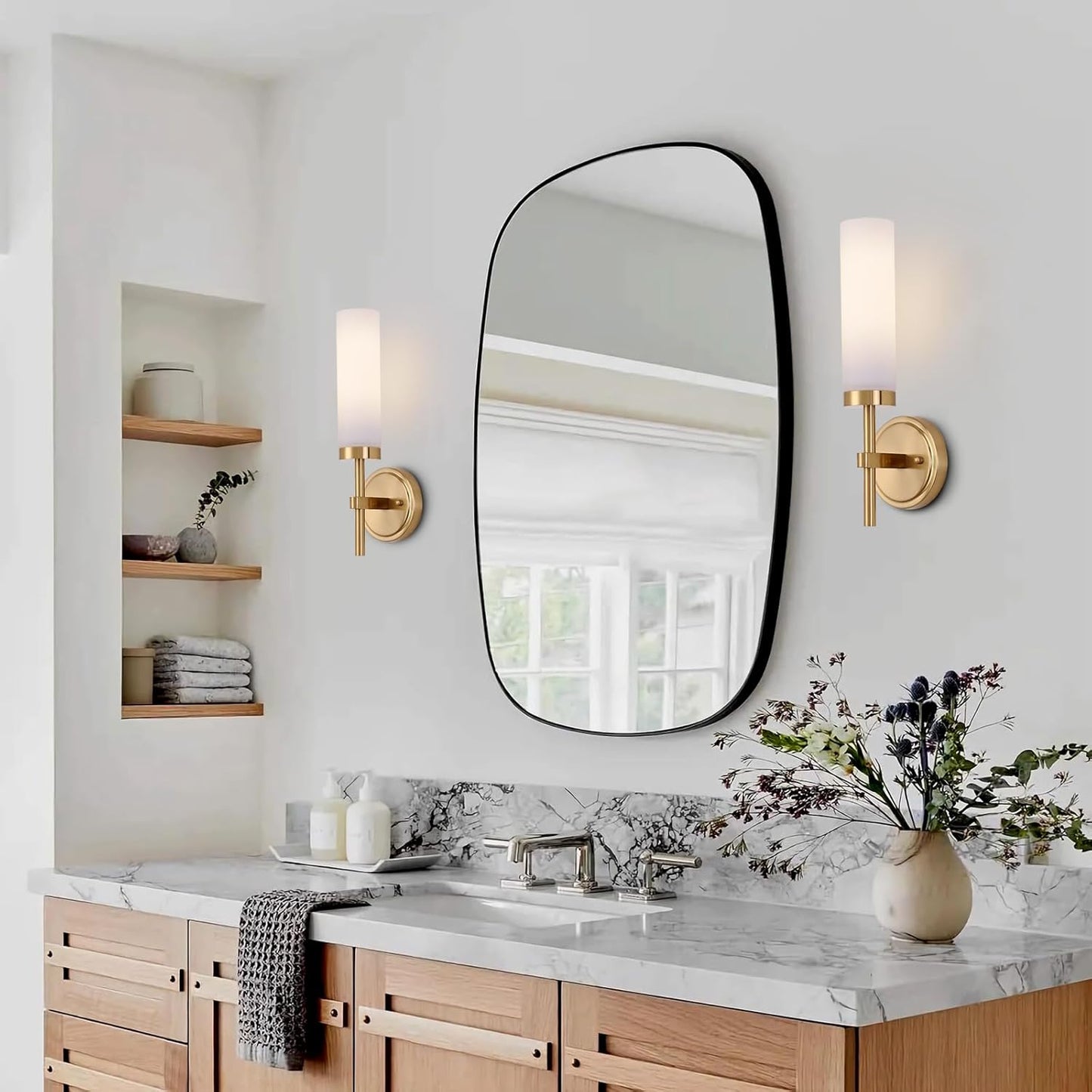 Bathroom with marble countertop, wooden cabinets, and a large round mirror.