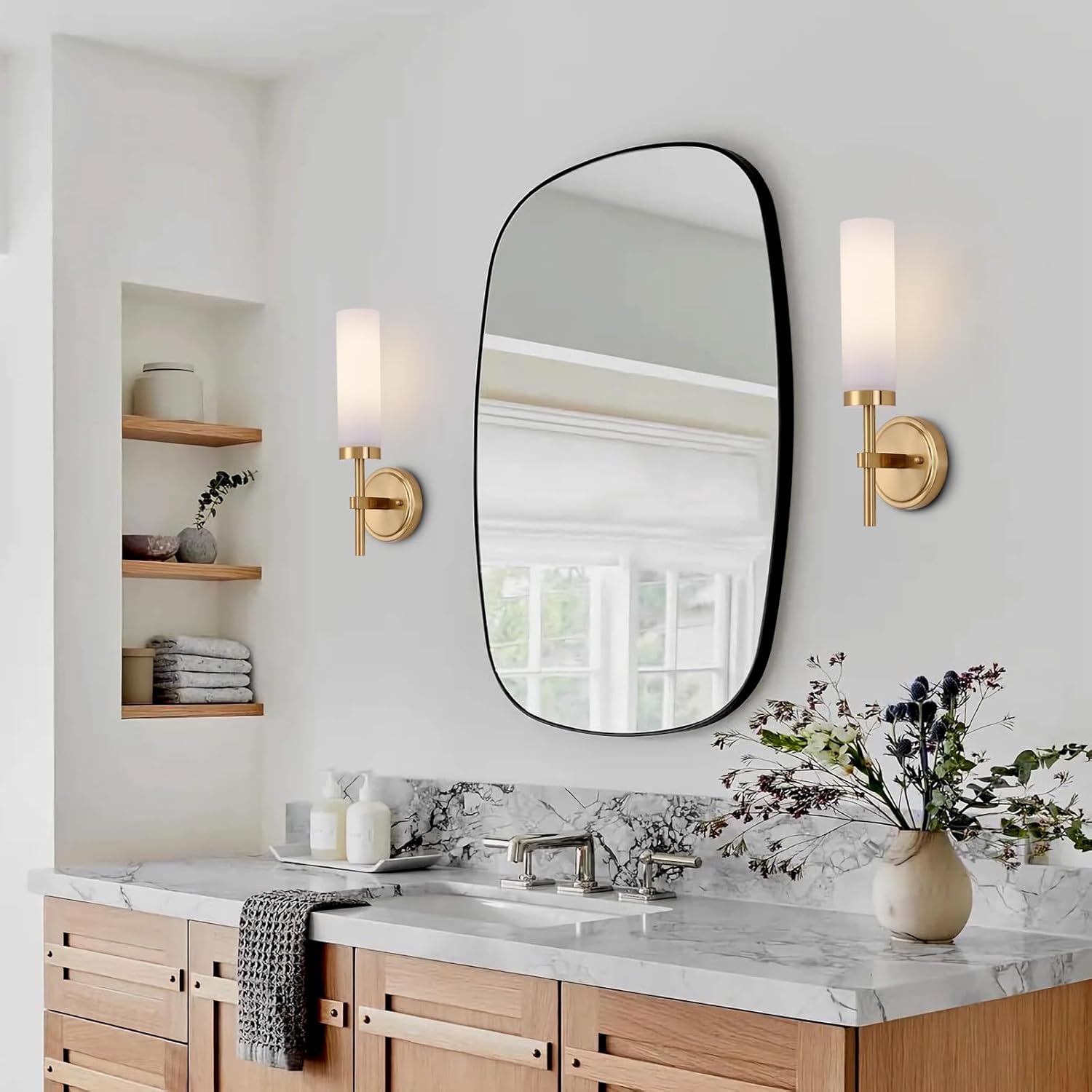 Bathroom with marble countertop, wooden cabinets, and a large round mirror.