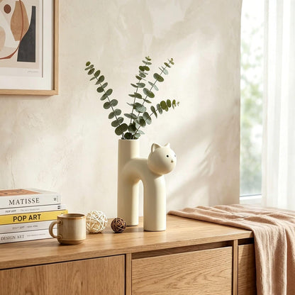 Decorative items on a wooden surface with a vase, mug, and books.