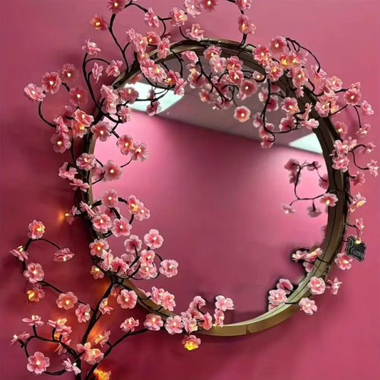 cherry blossom branch shaped led lights on mirror hanging on a pink wall