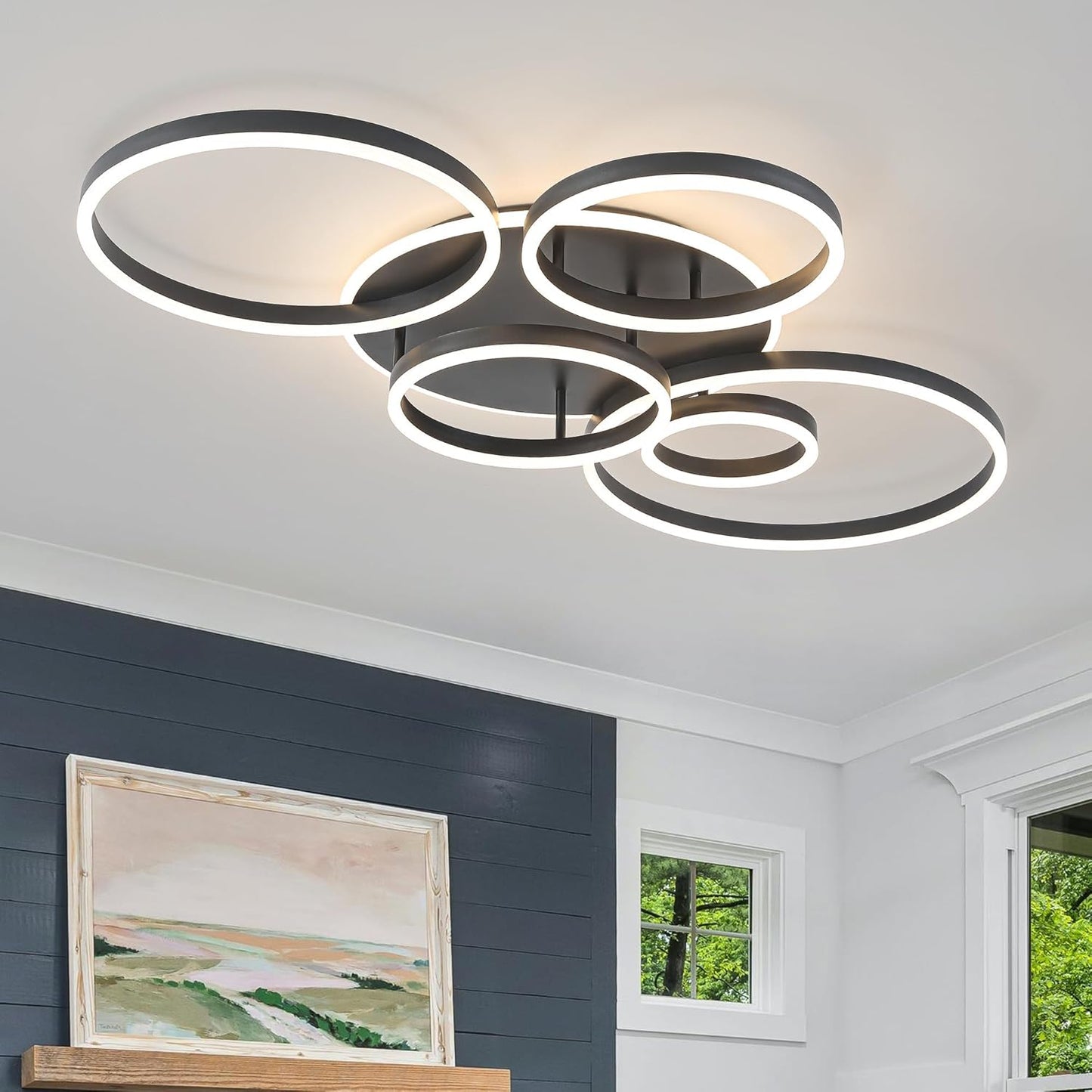 Modern ceiling light fixture in a room with a painting and window