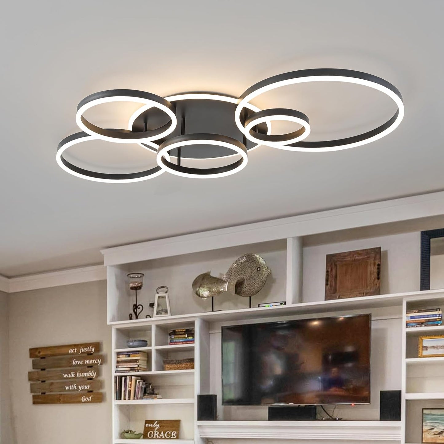 Modern ceiling light fixture in a living room setting with a television and shelves.