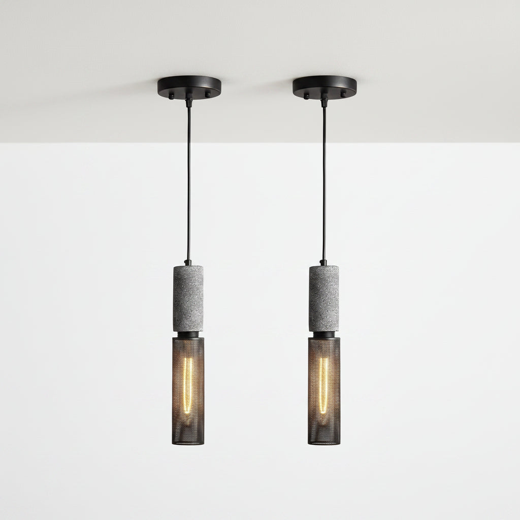 Two matching pendant lights shown side by side on a plain white background. Each light has a black ceiling canopy and cord, a textured gray cylindrical middle section, and a dark mesh lower shade with a glowing warm bulb inside.