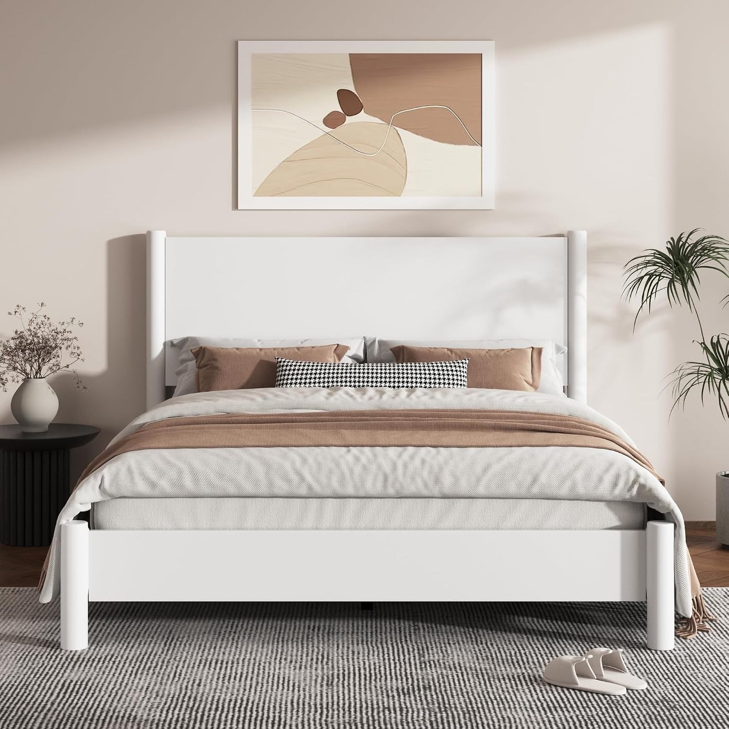 A modern white wooden bed frame with a tall rectangular headboard and matching footboard, styled in a minimalist bedroom with beige and brown bedding, a patterned pillow, a side table with a vase, and a framed abstract print on the wall.