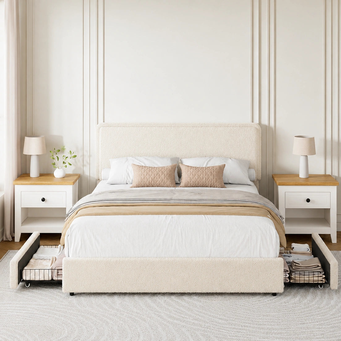 A cream upholstered bed frame with two pull-out storage drawers underneath, styled in a bright, modern bedroom with white bedding, wooden nightstands, and lamps.