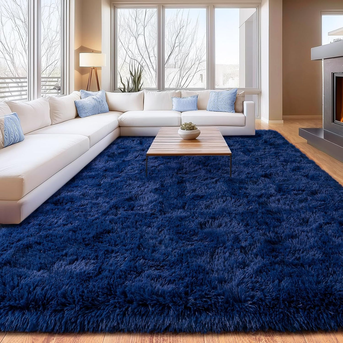 Living room with a blue rug, white sectional sofa, and coffee table.