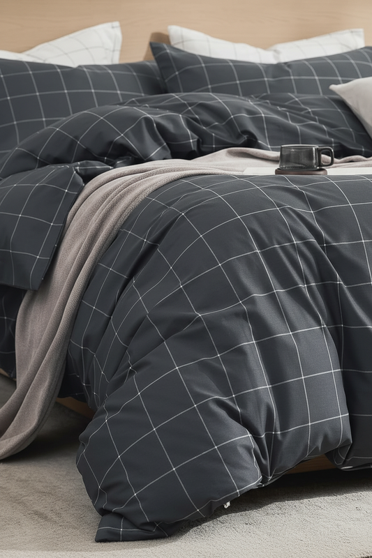 A dark gray bedding set with a white windowpane grid pattern, styled on a bed with a light gray throw blanket and white pillows.