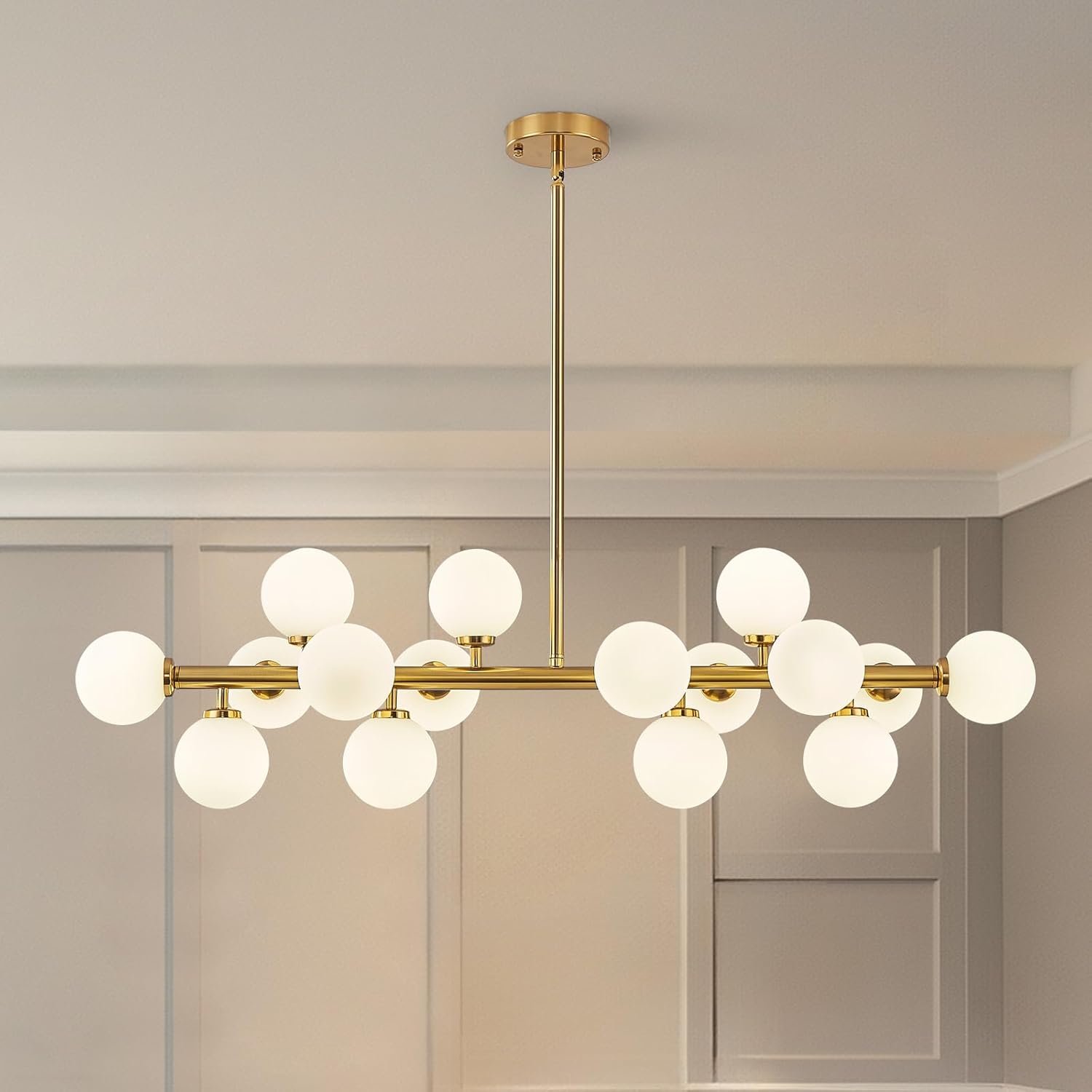 Modern chandelier with gold fixtures and white glass shades in a room setting.