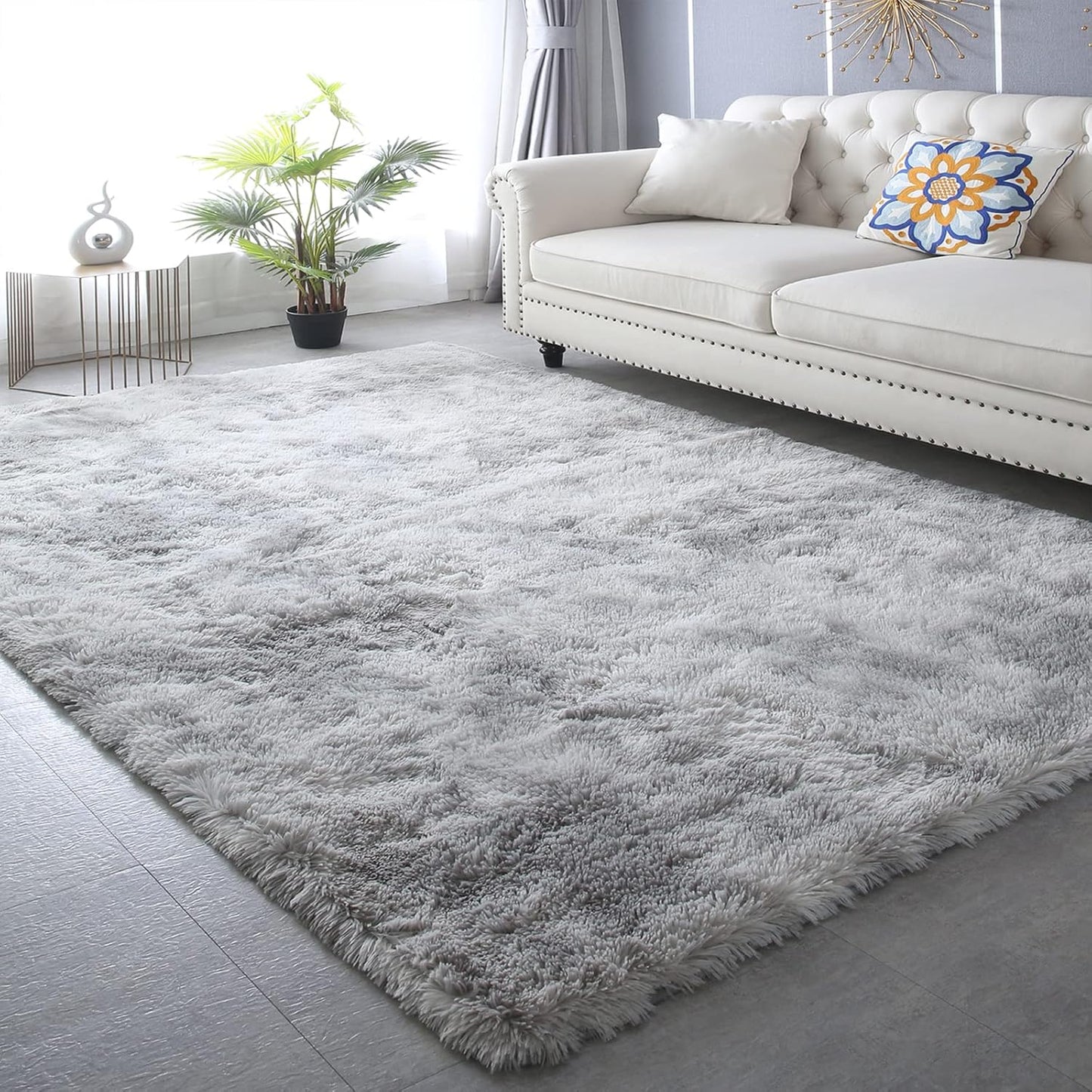 Gray shaggy rug in a living room with a white sofa and decorative elements.