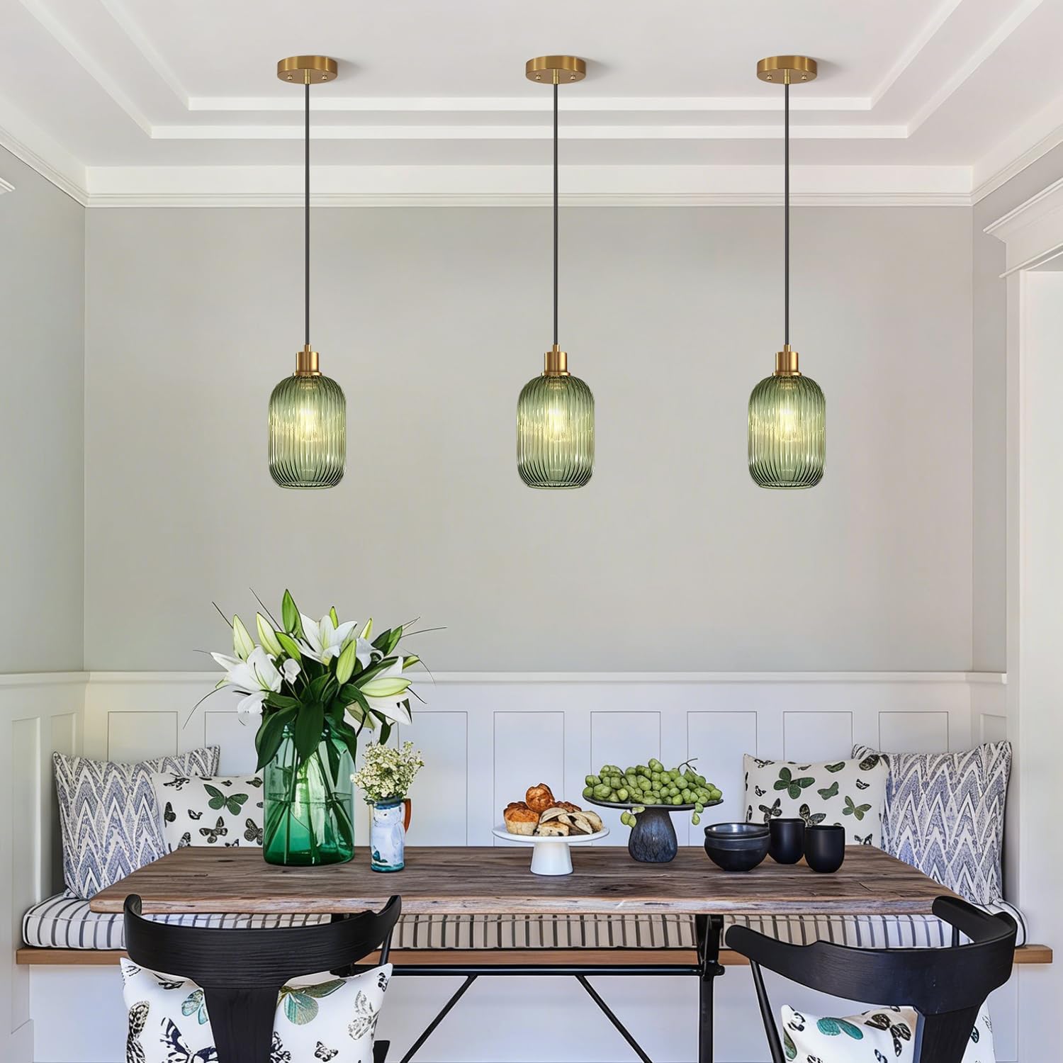 Dining room with wooden table, chairs, and pendant lights.